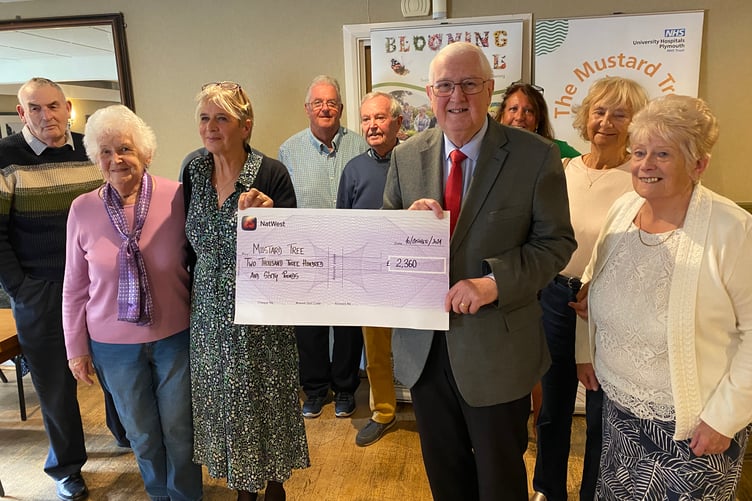 Customers of Tavistock's West Devon Club present the Mustard Tree and Blooming Well cancer charities with sponsorship fundsJPG