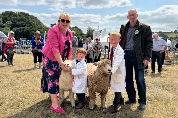 Young sheep handler champion was Jack Darke (7), third left, from Kingsbridge, and runner-up was his cousin, Freya Uglow (4), from Launceston. Left is judge Ann Willcocks from Ivybridge and right, Colin Braine from Okehampton, who made and presented Jack with a shepherd’s crook.  AQ 0974
