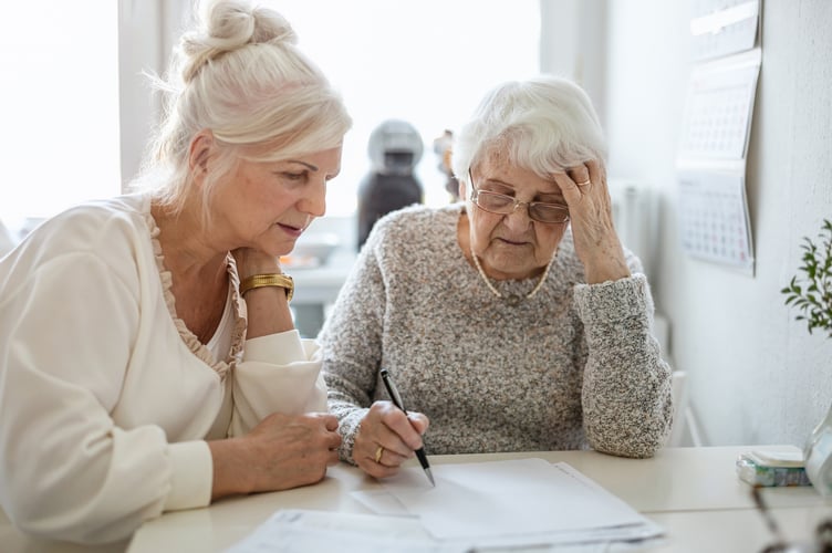 Woman helping her elderly mother preparing financial documents