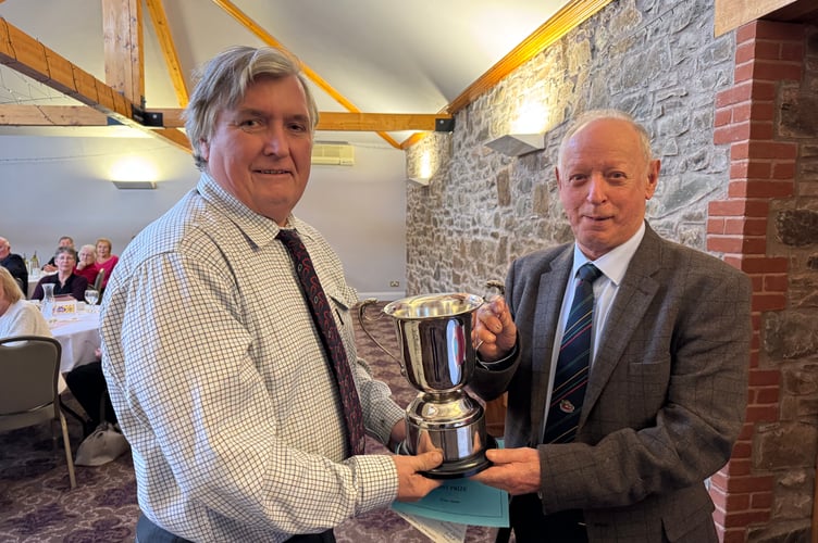 Peter Stone, left, receiving the Devon County Champion Ploughman award for 2025 from President Raymond Govier. AQ 7123