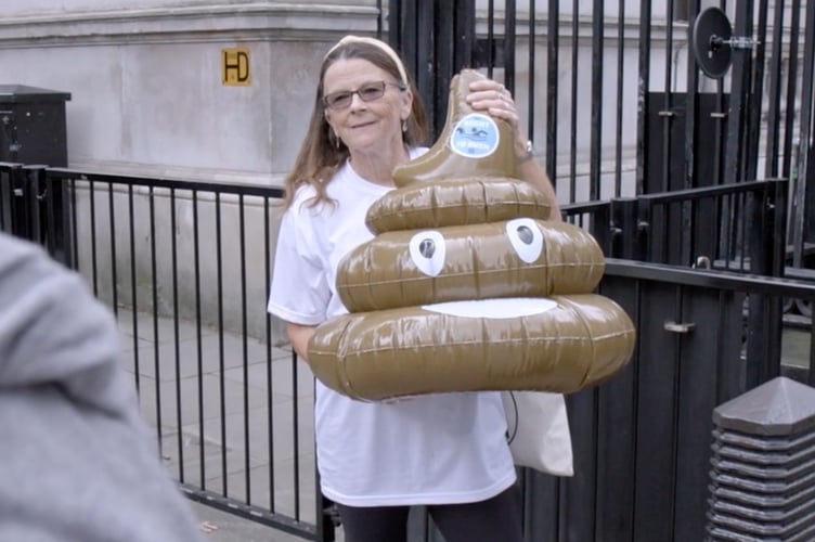 Water pollution activist Jo Bateman is pictured delivering an inflatable poo to Downing Street.  A film 'Jo in the Water', highlighting her campaigning will be screened in June in Tavistock Library. Picture courtesy of Fair View Films.