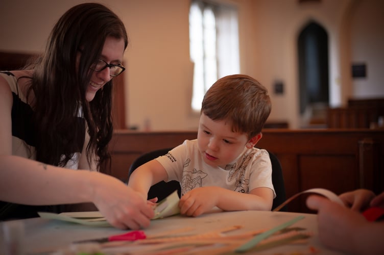Mum Rebecca helps her son Mylo, 3, learn paper weaving during a Tavistock Heritage Trust half-term session in the Guildhall.  Picture by Sam Griffith.