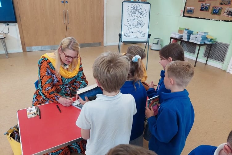 Lifton pupils queue up to meet children's author Sarah McIntyre.