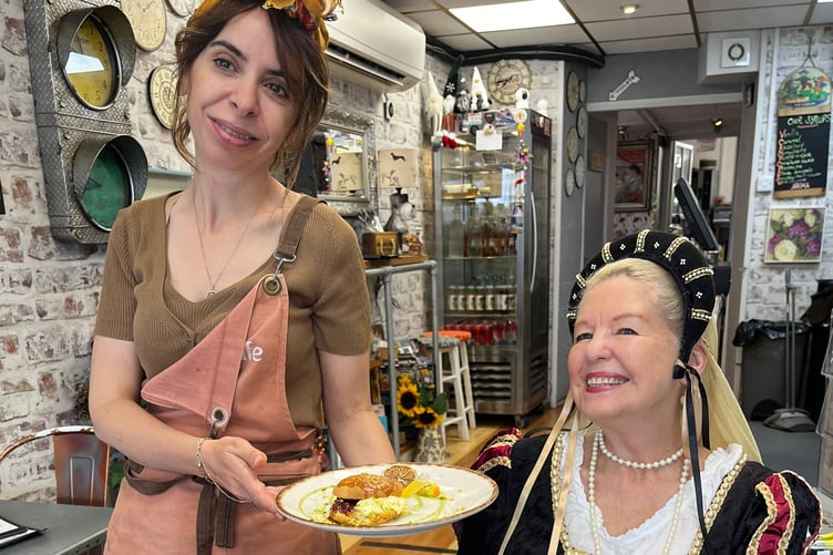 Ummi xxx of Aroma Cafe, serves up her Tavistock Cream Tea Festival delights for Bev Moody (dressed as a member of Edge Players), a member of the festival tasters.