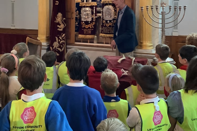 Pupils are welcomed by the Rabbi in a Synagogue during their day trip to places of worship.