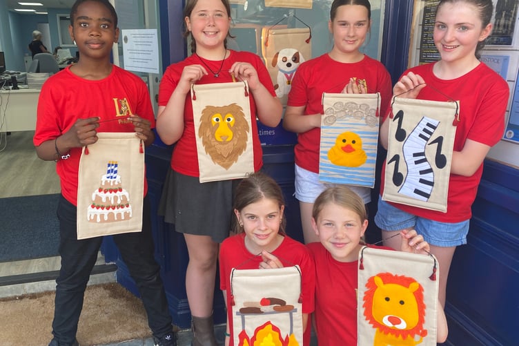 Tavistock Lions town carnival week young ambassadors show off the banners to promote aspects of the week's attractions: Pelum (cake banner), Hallie and Esther (both lions), Evie (duck), Eden (BBQ) Chloe (piano music).