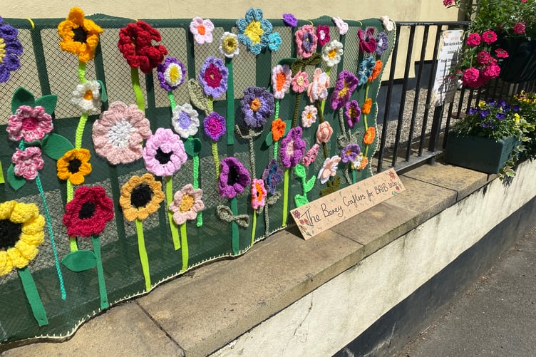 A mural of crocheted flowers decorate railings in Bere Alston for the judging of the Bere Alston In Bloom competition.