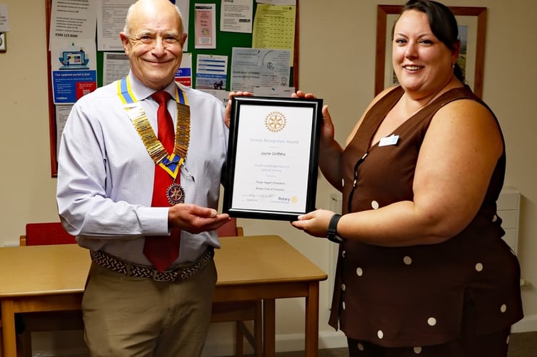 Yelverton Co-op manager Jane Griffiths being presented with a Rotary citizenship award by Nigel Tidwell, president of Yelverton Rotary.