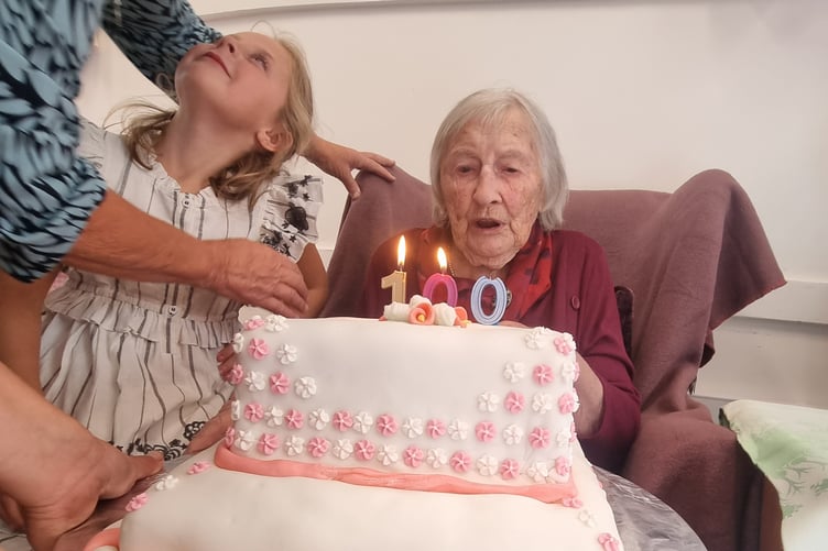 Ena Medland blows out the candles on her 100th birthday cake, with daughter-in-law Jayne and one of her great-grandchildren. Picture: Carol Beavis.